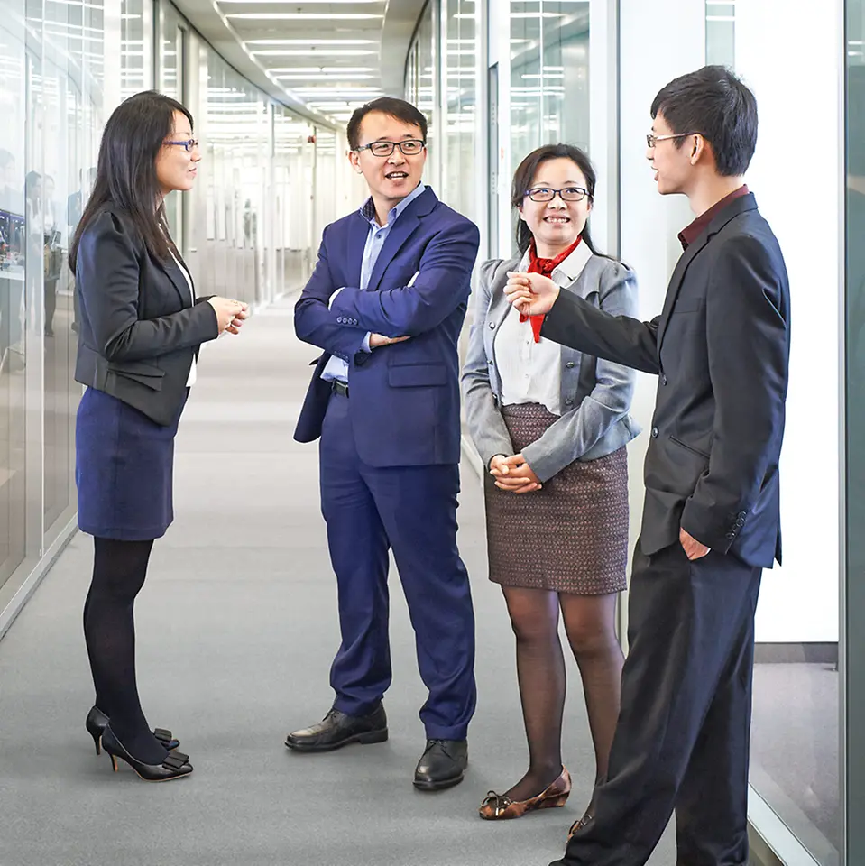 Asian employees in a hallway.