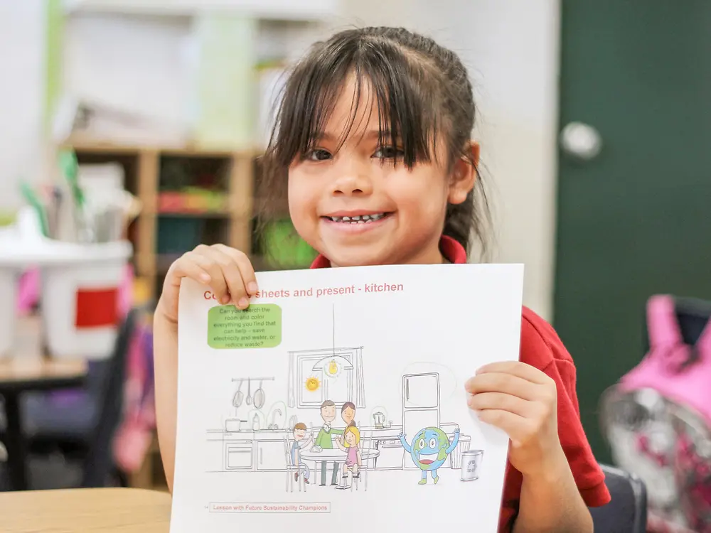 girl holding sustainability teaching materials